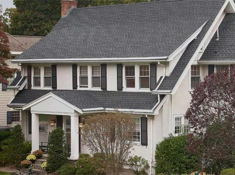 Front view of a typical mid-class home with dark gray GAF shingles